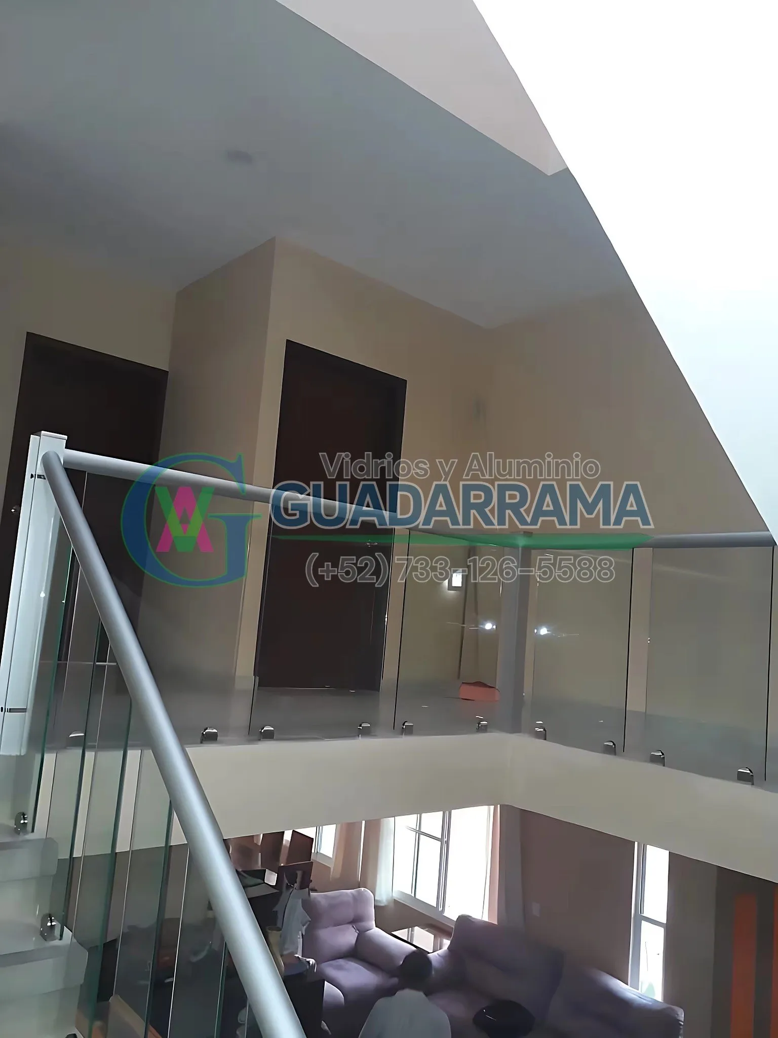 Barandal de vidrio templado transparente instalado en escalera, con perfilería en aluminio natural y paños fijos que realzan la vista del espacio.