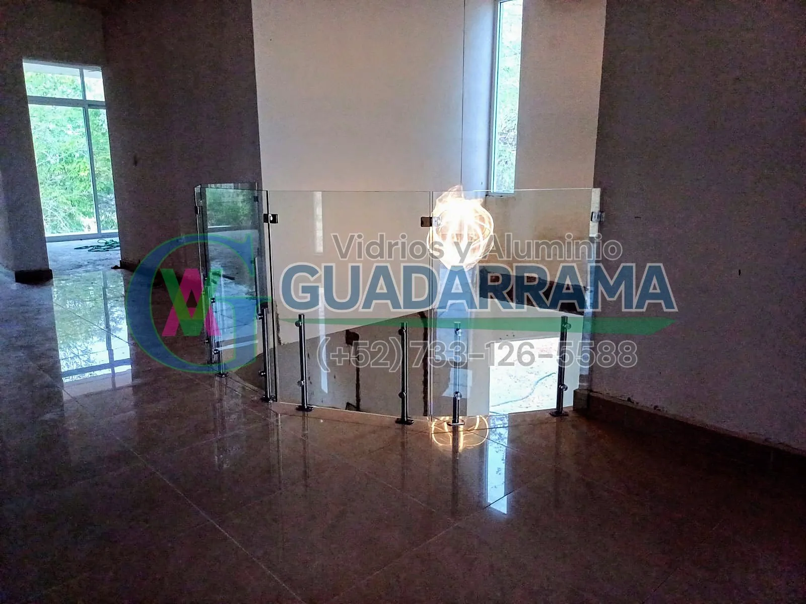 Barandal de vidrio templado transparente en forma curva, acabado natural para espacios modernos y luminosos.