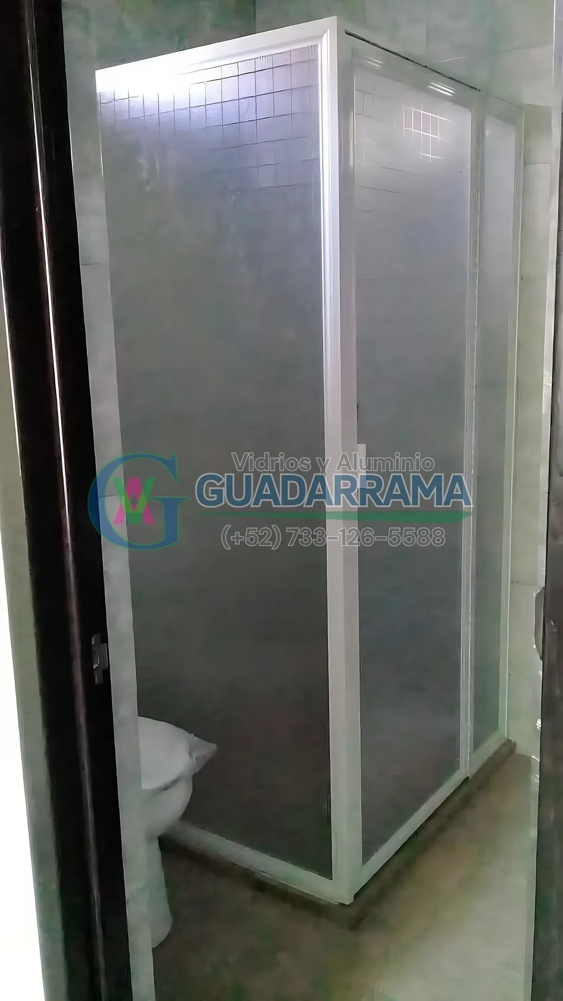 Cancel abatible en baño con panel de plástico blanco y diseño de cuadros.