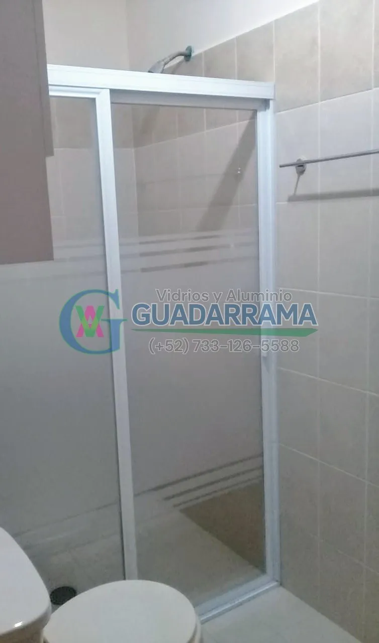 Cancel de baño con vidrio esmerilado y marco de aluminio blanco en acabado liso.