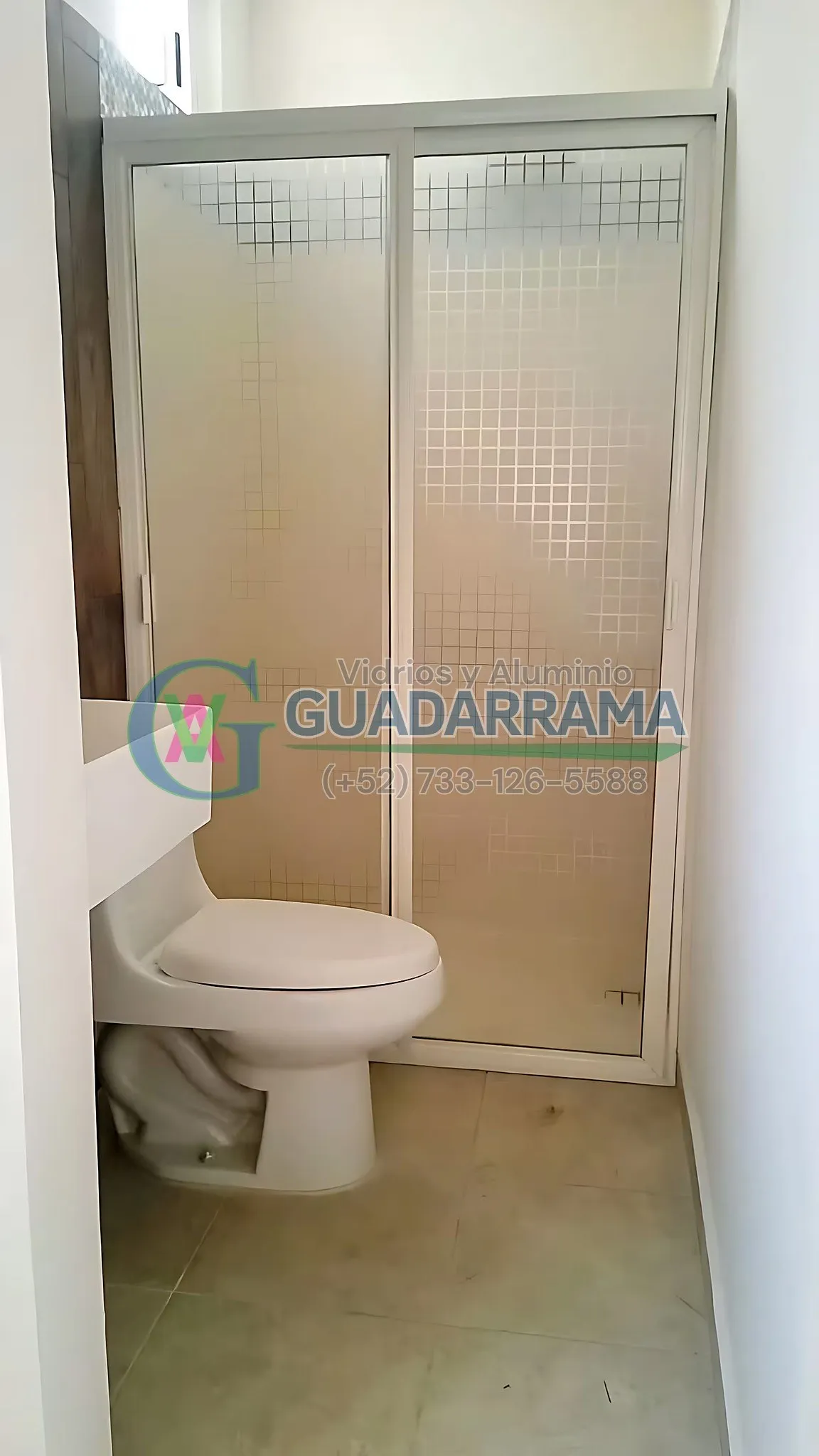 Cancel corredizo para baño en aluminio blanco, con panel de plástico a cuadros.