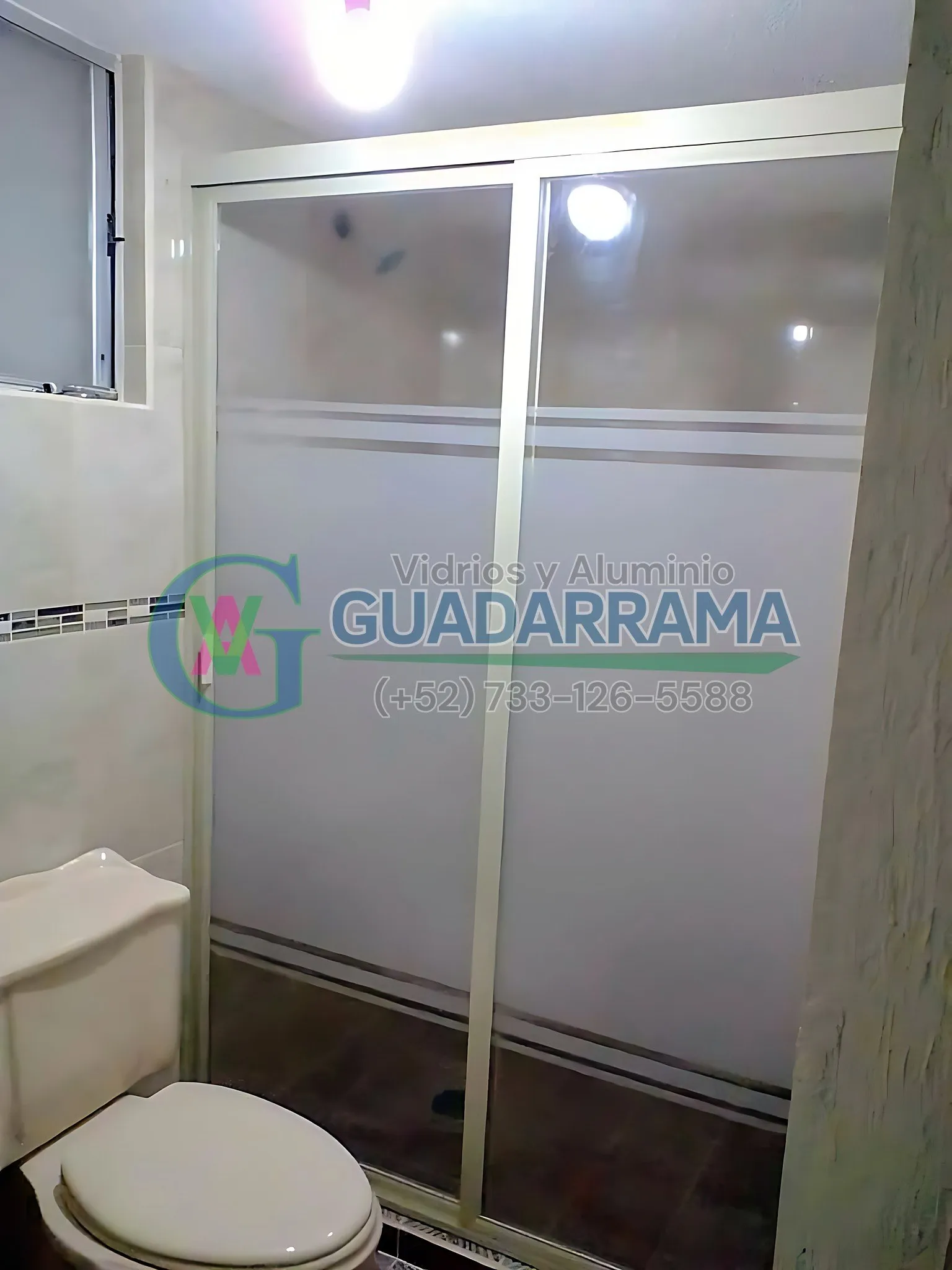 Cancel de baño en aluminio blanco con vidrio decorativo esmerilado, en dos hojas corredizas.