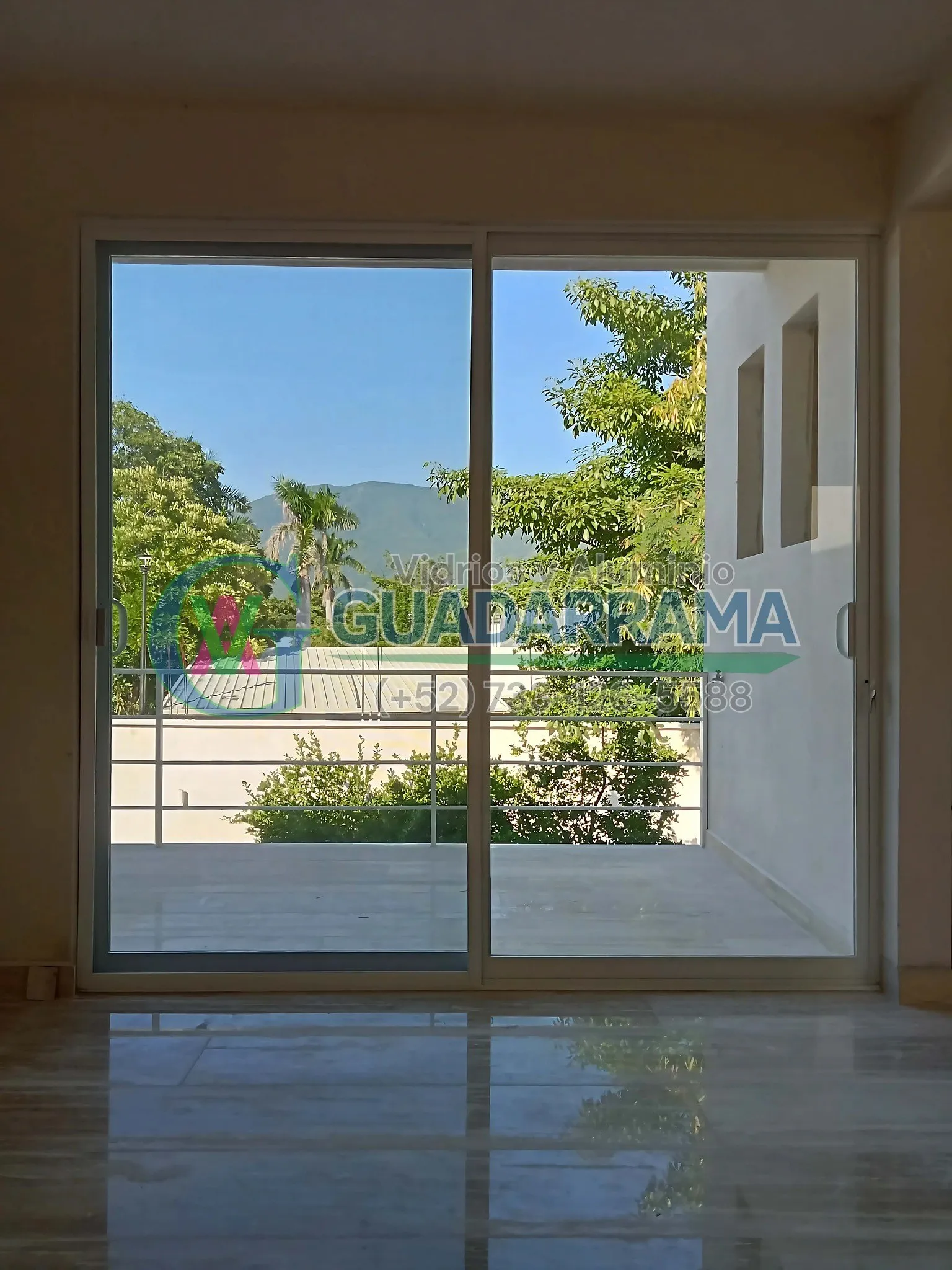 Cancel corrediza en aluminio blanco con vidrio transparente y mosquitero integrado, ideal para espacios exteriores que buscan ventilación y protección.