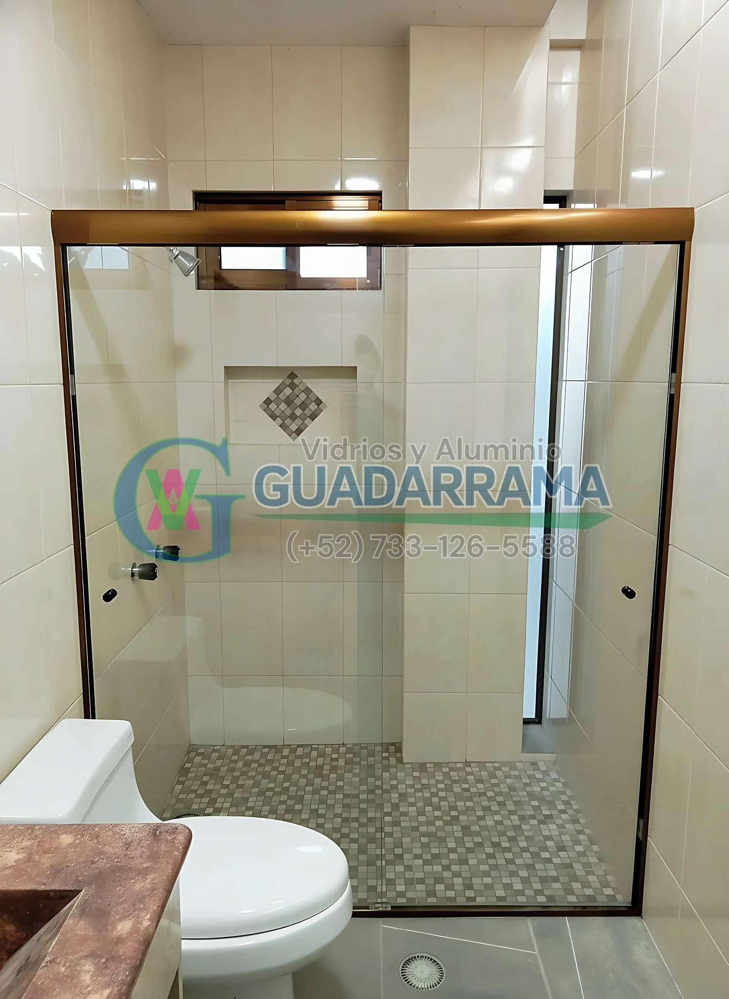 Cancel de baño corredizo en vidrio templado transparente con película esmerilada para mayor privacidad, enmarcado en aluminio champagne.