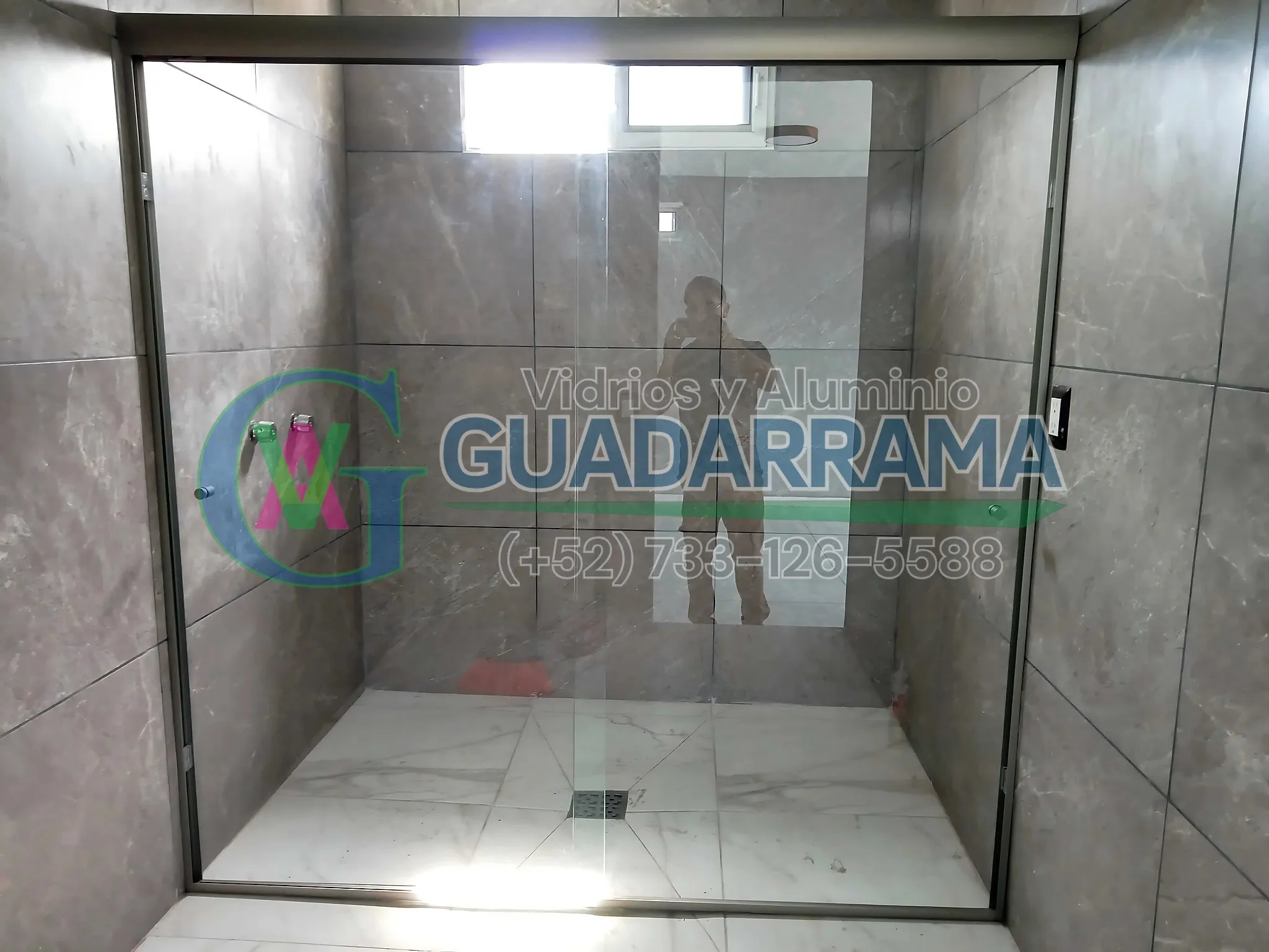 Un cancel corredizo para baño con vidrio templado transparente y perfil champagne.