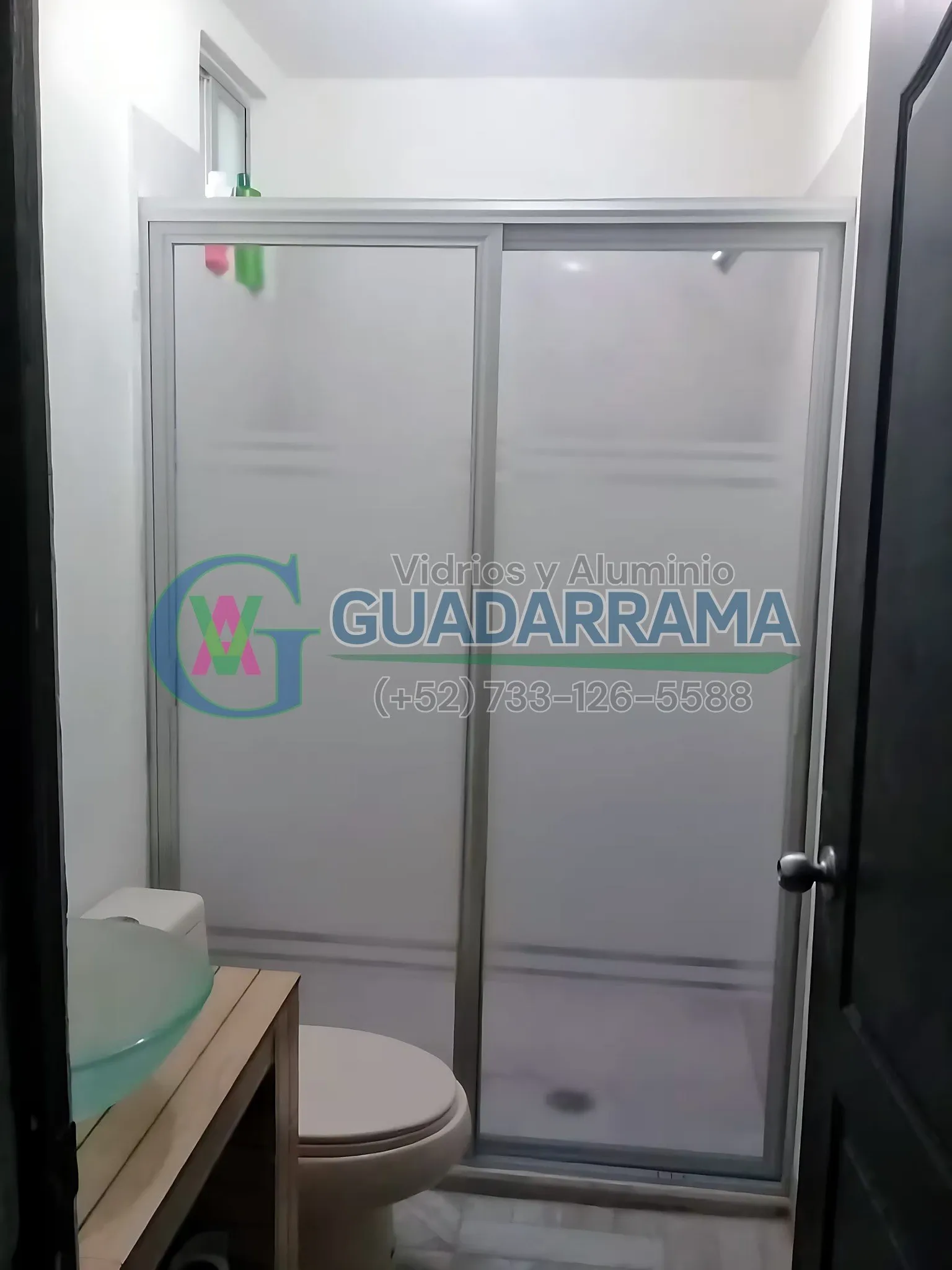 Cancel de baño corredizo instalado con panel plástico y película esmerilada: privacidad sin perder la elegancia.