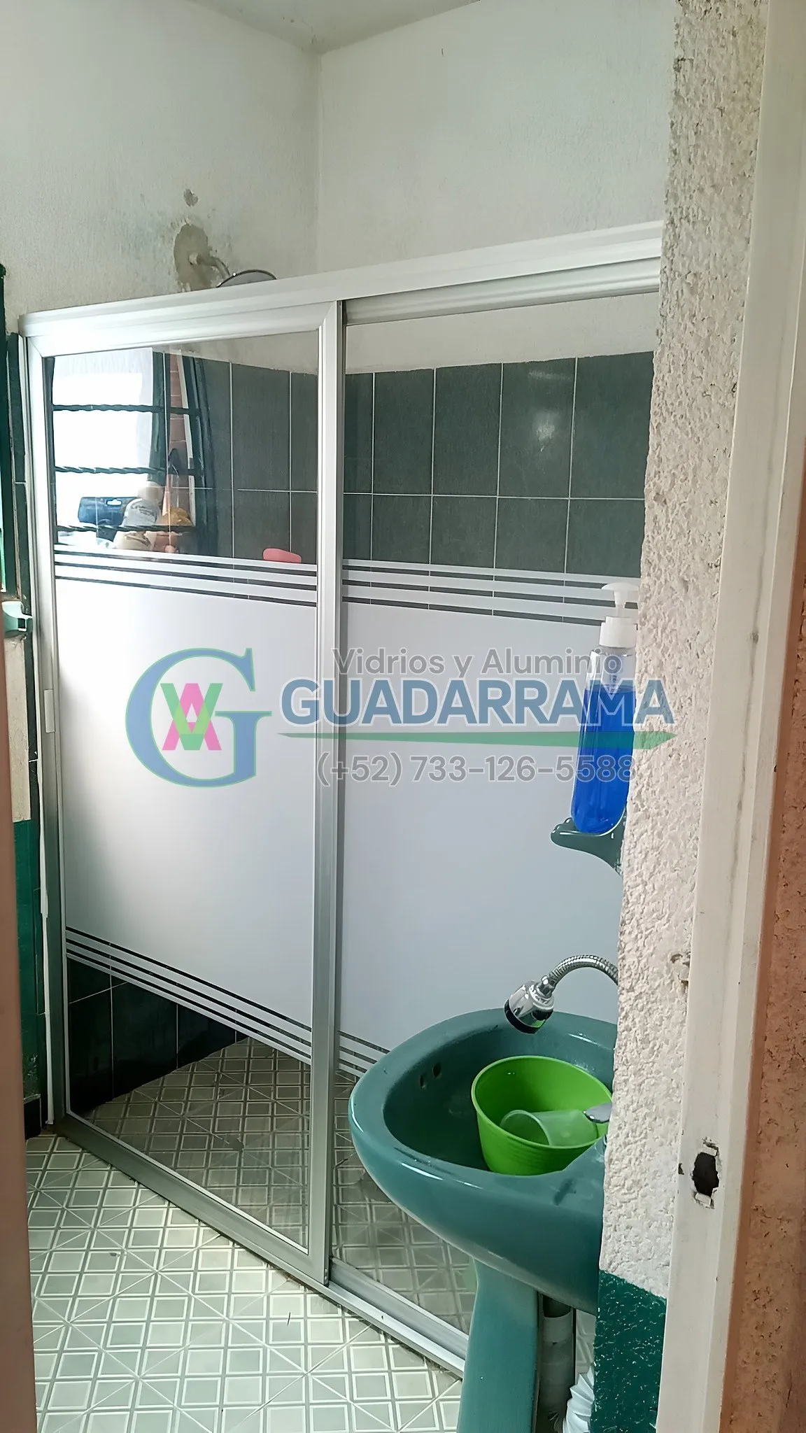 Cancel corredizo para baño con perfil en color natural y paneles de plástico con película esmerilada, una opción práctica y ligera para dividir el espacio.