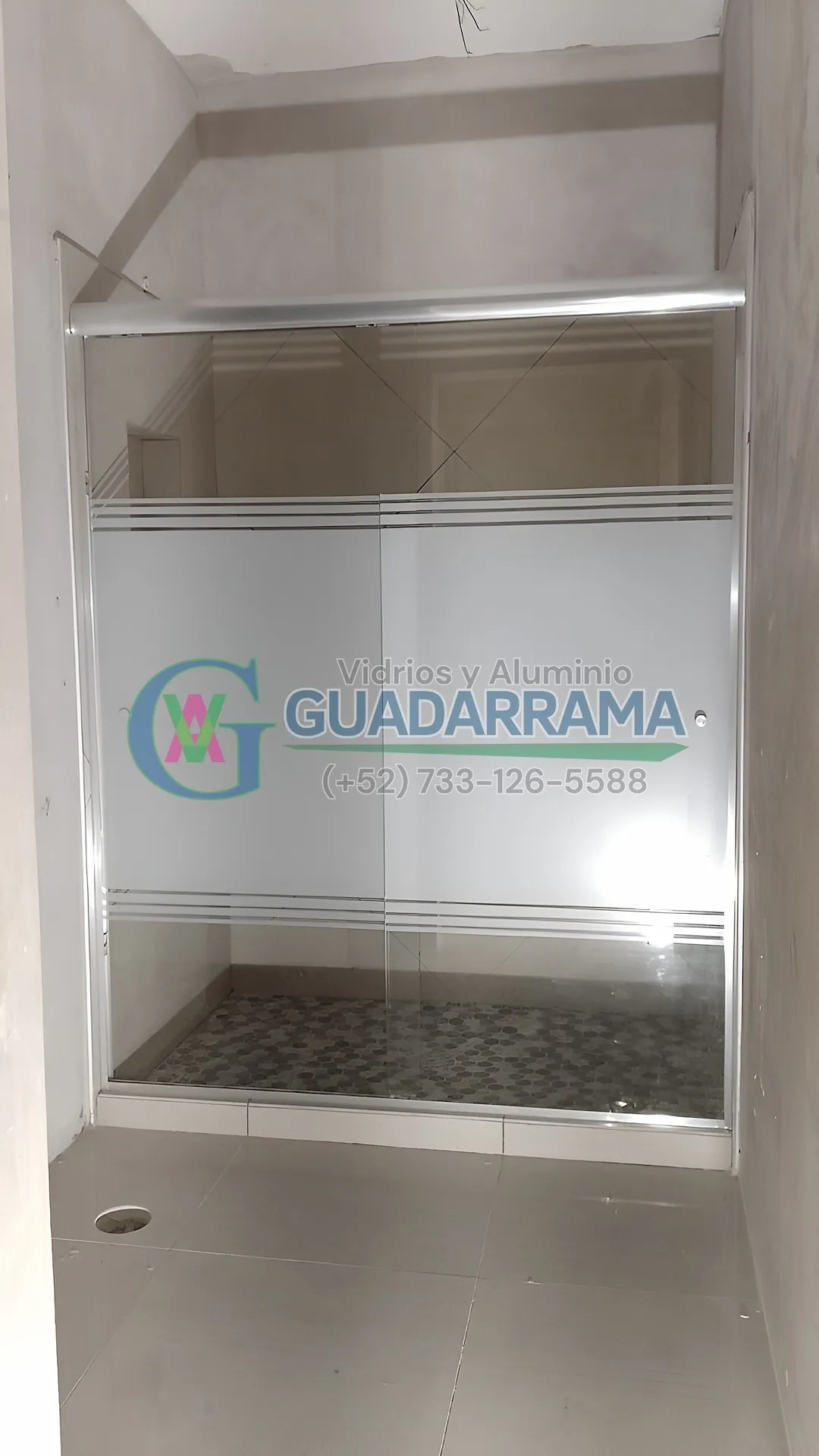Cancel corredizo de aluminio natural con vidrio templado transparente y película esmerilada, ideal para regaderas.