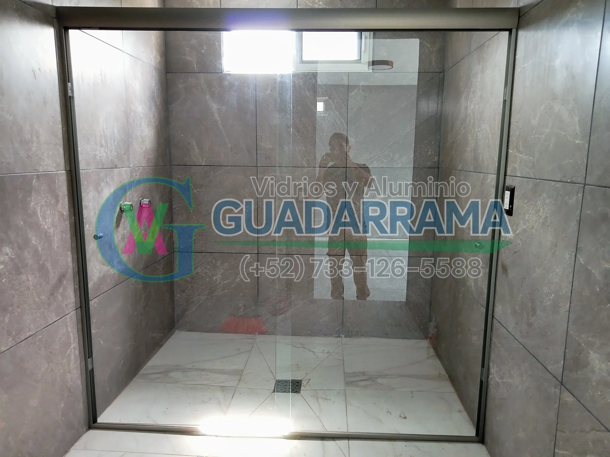 Un cancel corredizo para baño con vidrio transparente.