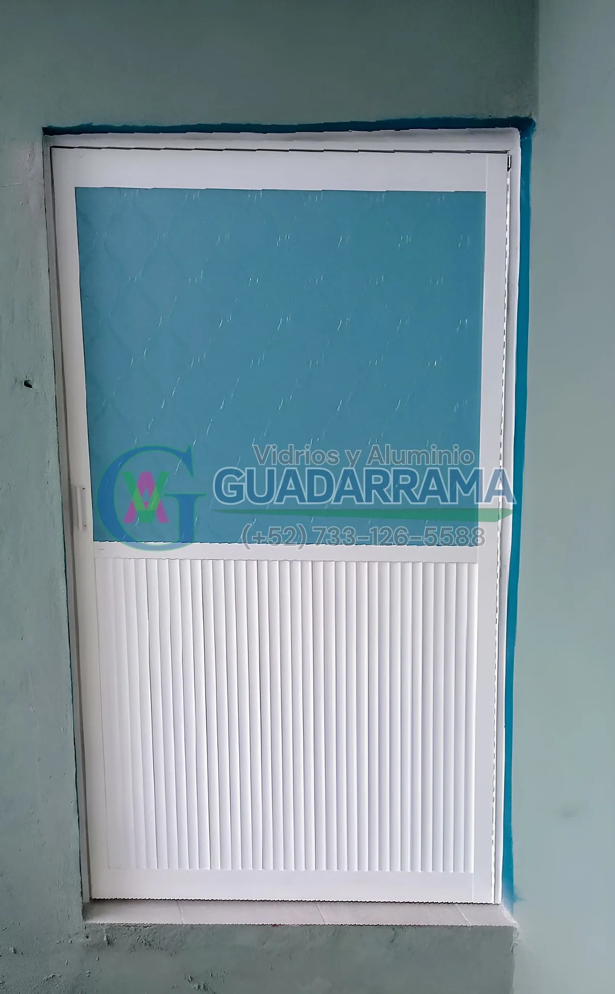 Puerta abatible para baño en acabado blanco, con panel de plástico azul cielo que aporta privacidad.