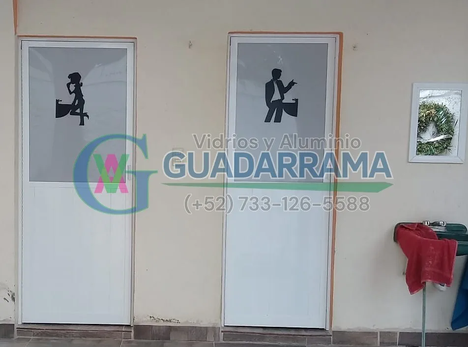 Puertas abatibles con duela lisa blanca y diseño decorativo tipo silueta, ideales para baños con un toque moderno y elegante.