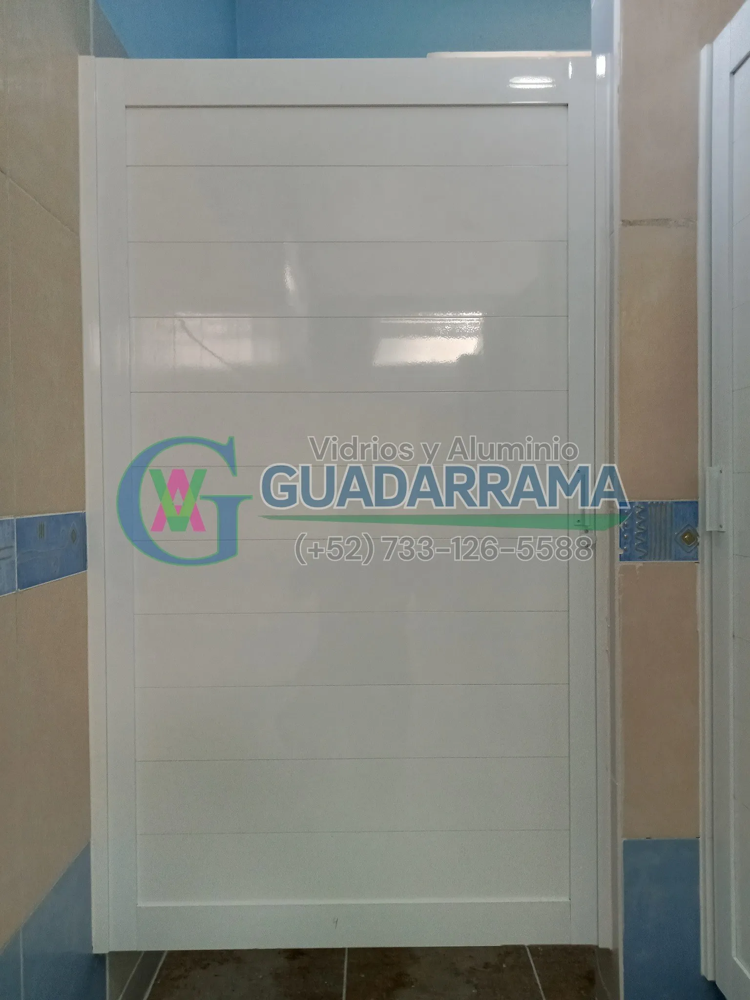 Puerta abatible para baño, en aluminio blanco y vidrio templado.