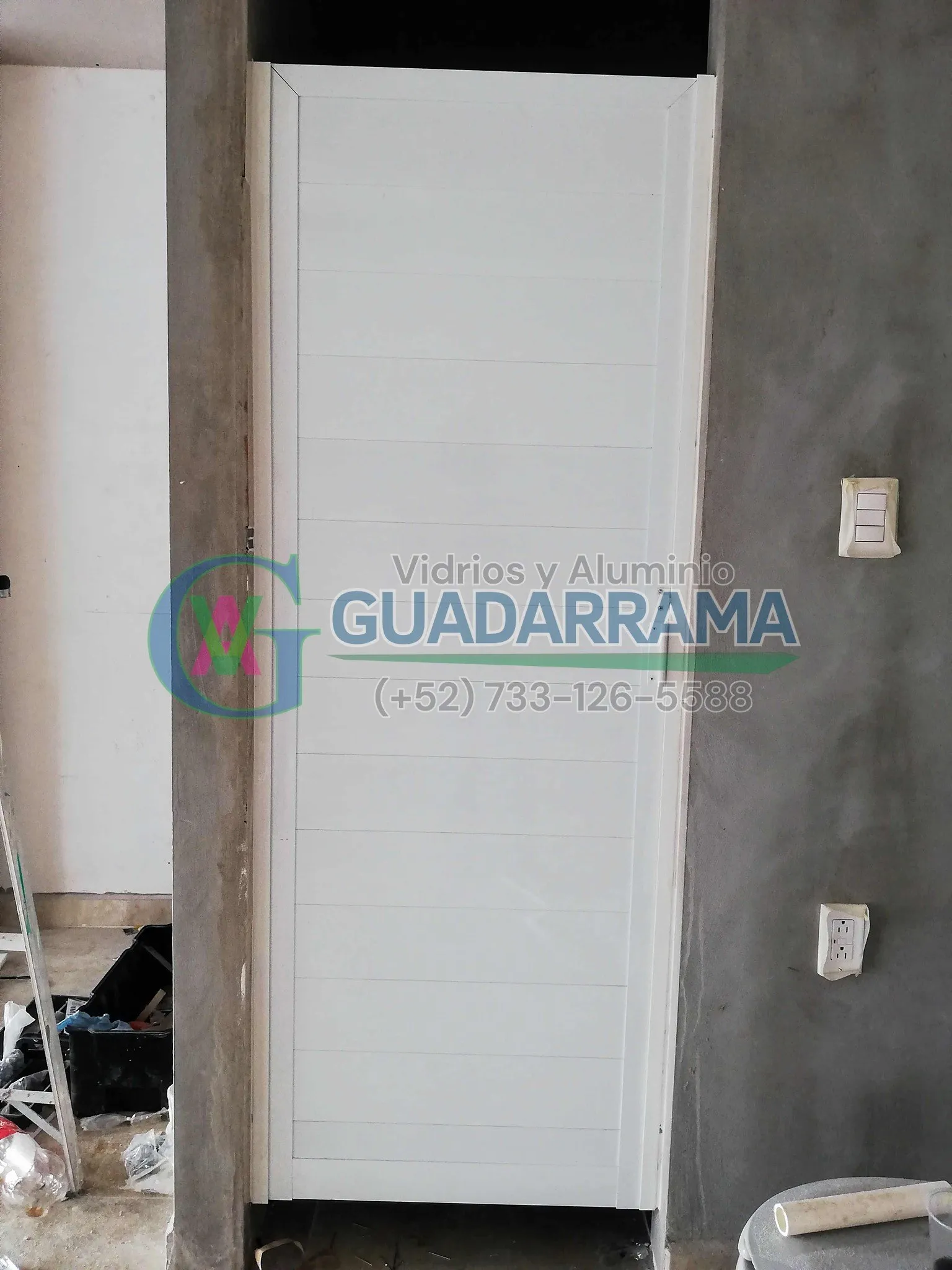 Puerta abatible para baño en blanco con acabado de duela lisa, equipada con una práctica jaladera tipo trompa de elefante.