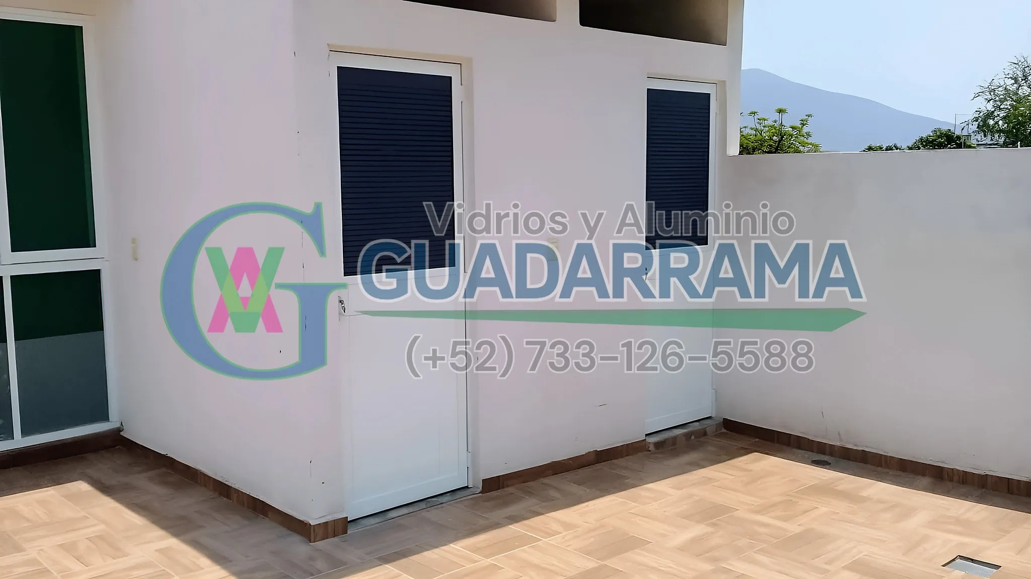 Puerta abatible para exterior en aluminio blanco con vidrio reflectasol.