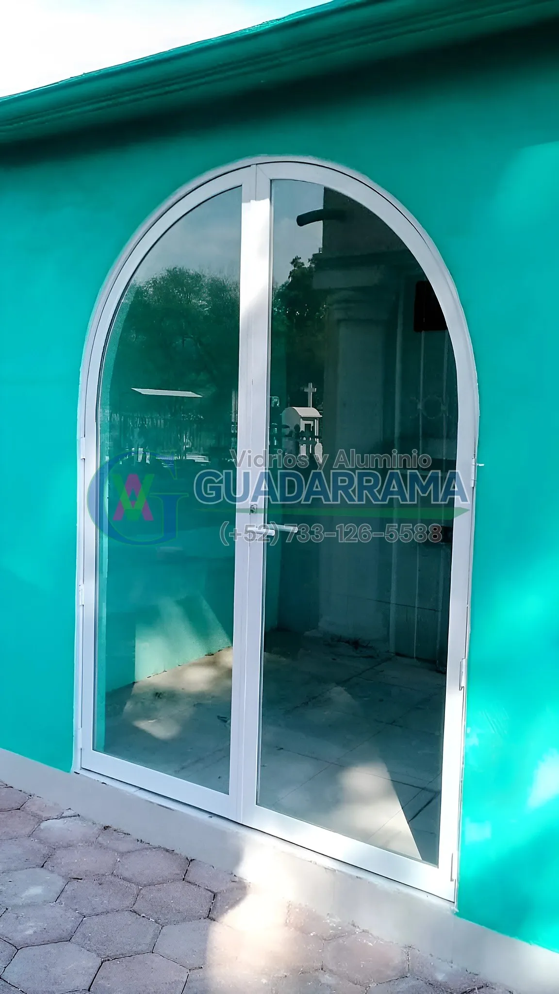 Puerta abatible de aluminio blanco para exterior, con vidrio tintex.