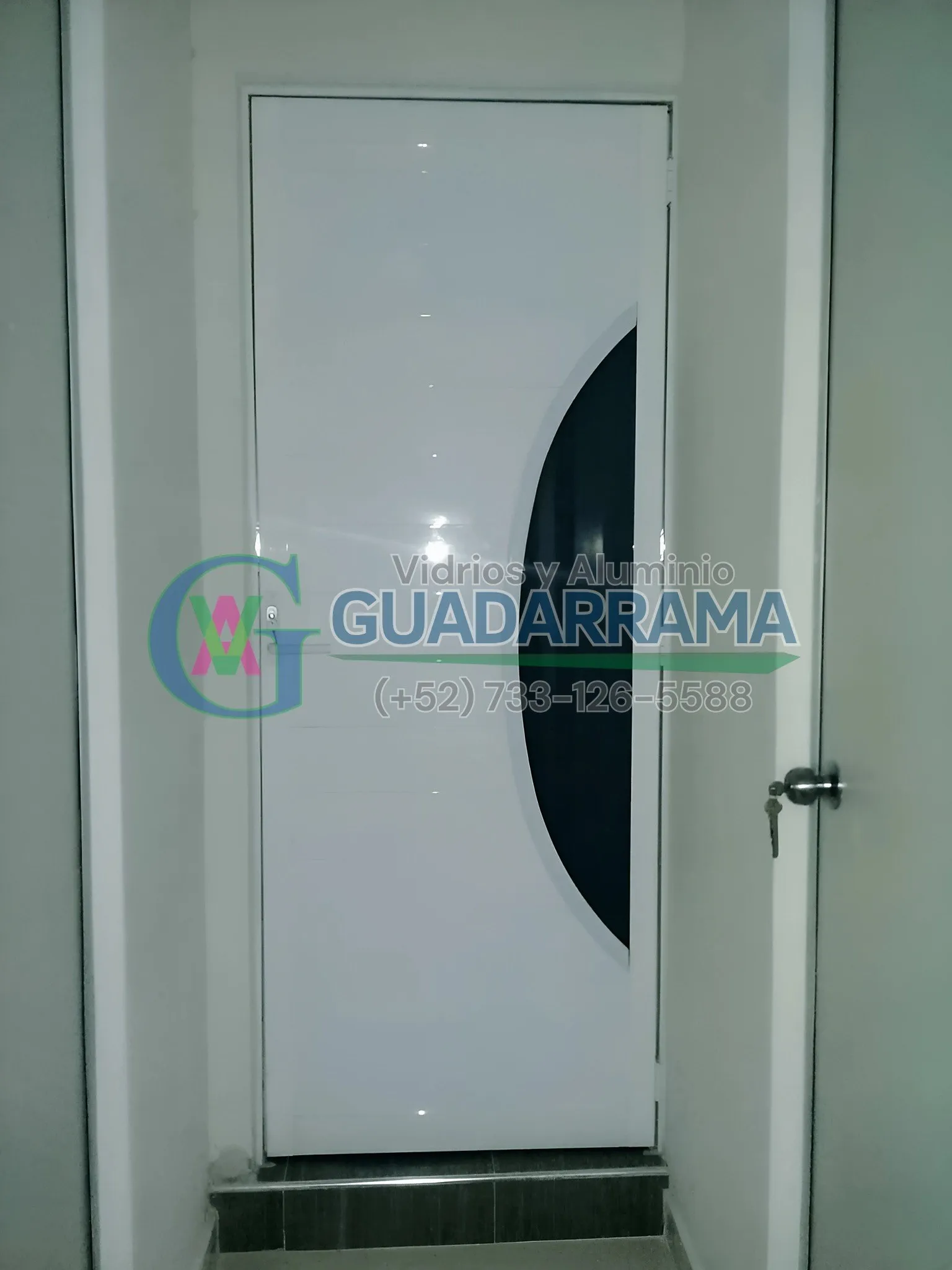 Puerta abatible de aluminio blanco con vidrio templado tintex para uso exterior.