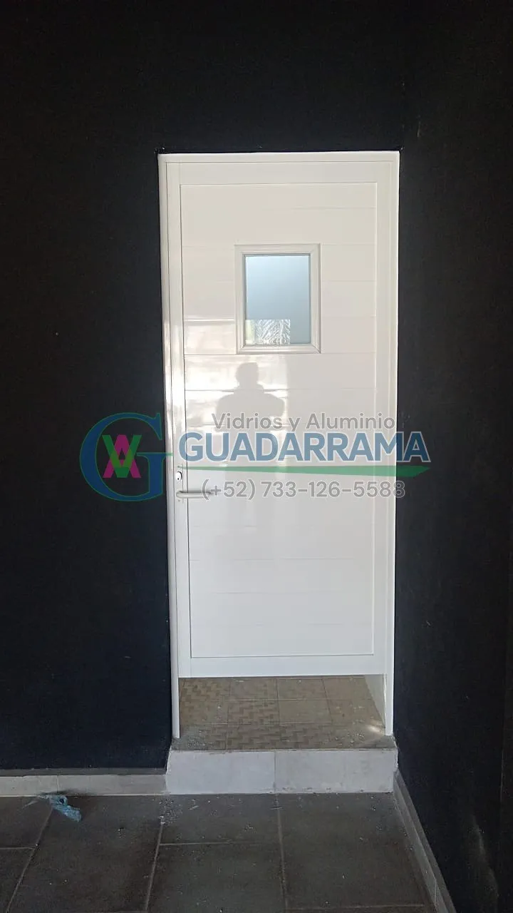 Puerta abatible en aluminio blanco para baño, con panel de vidrio transparente esmerilado: privacidad y luz natural sin sacrificar estilo.