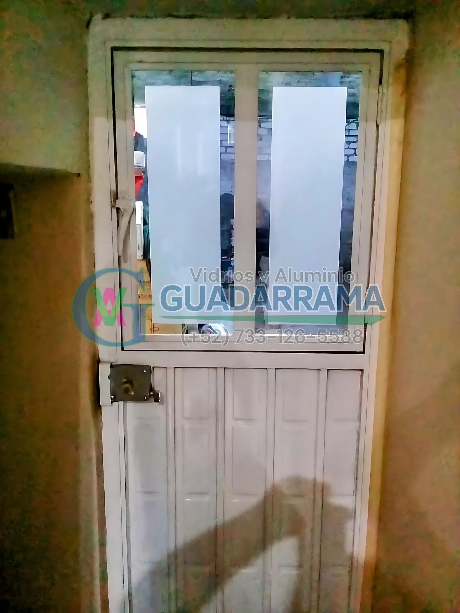Puerta abatible de aluminio blanco para exterior, con vidrio transparente esmerilado y una película decorativa que le da un toque único.