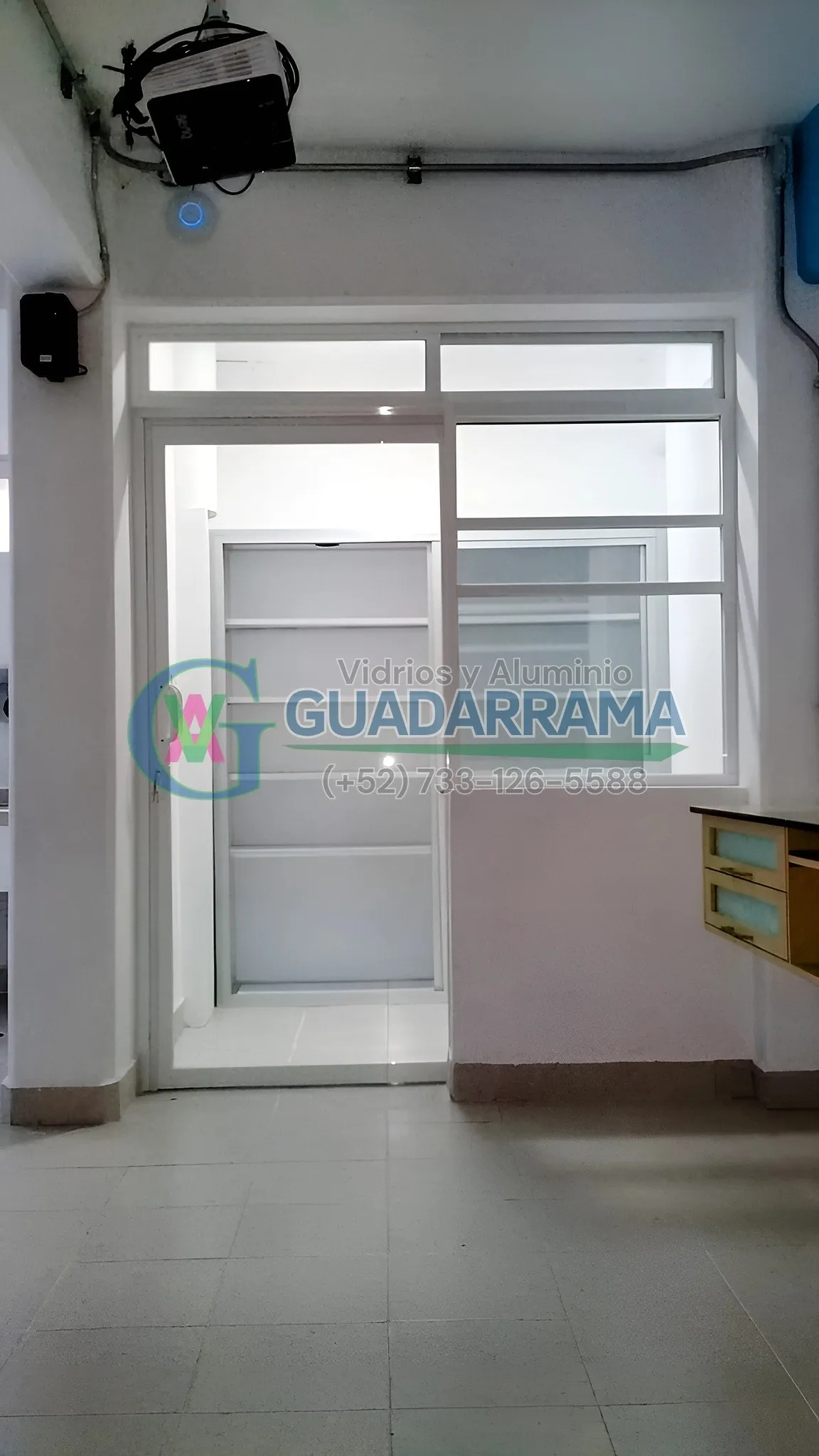 Puerta abatible de aluminio blanco para oficina con vidrio transparente.