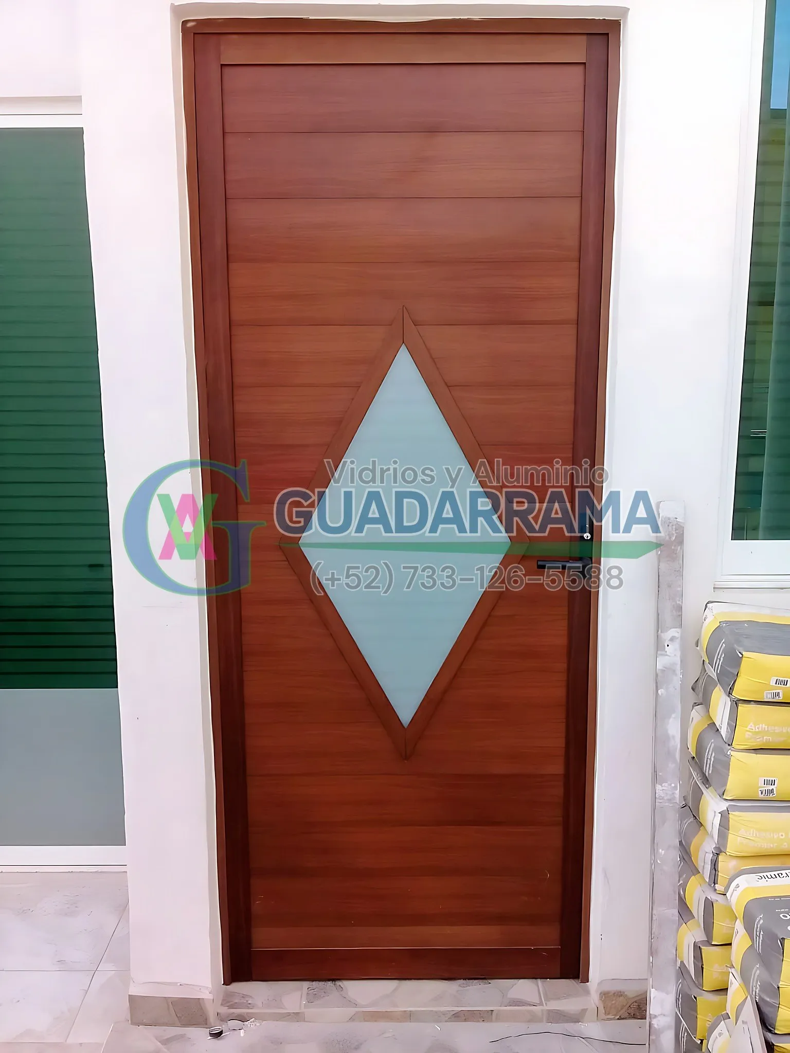 Puerta abatible de  aluminio imitación madera con diseño diamante en duela lisa, realzada con un paño de vidrio esmerilado tipo tintex que deja pasar la luz sin perder privacidad.