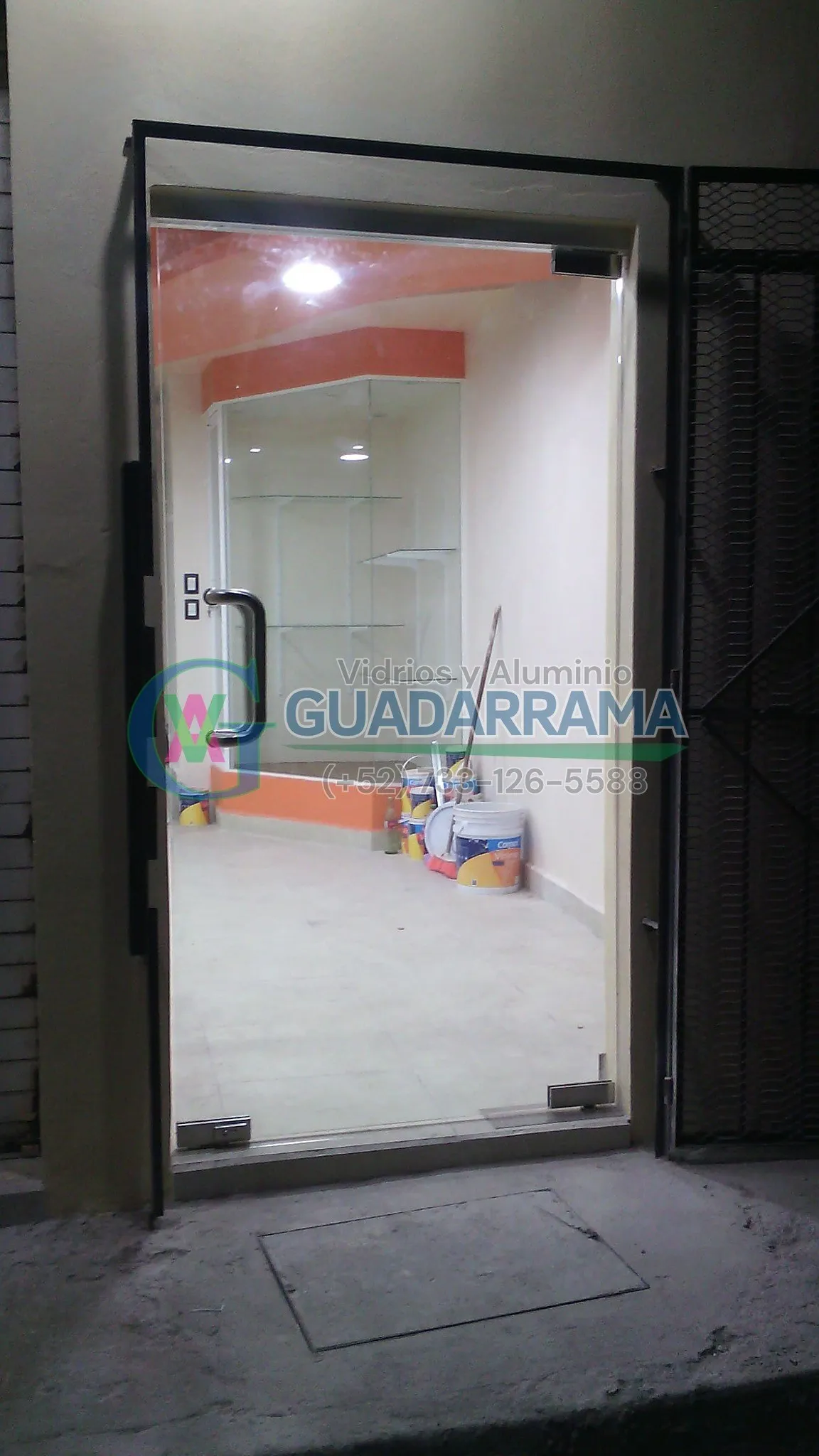 Puerta abatible de vidrio templado transparente para oficina, donde el cristal natural maximiza la entrada de luz y aporta amplitud al espacio.