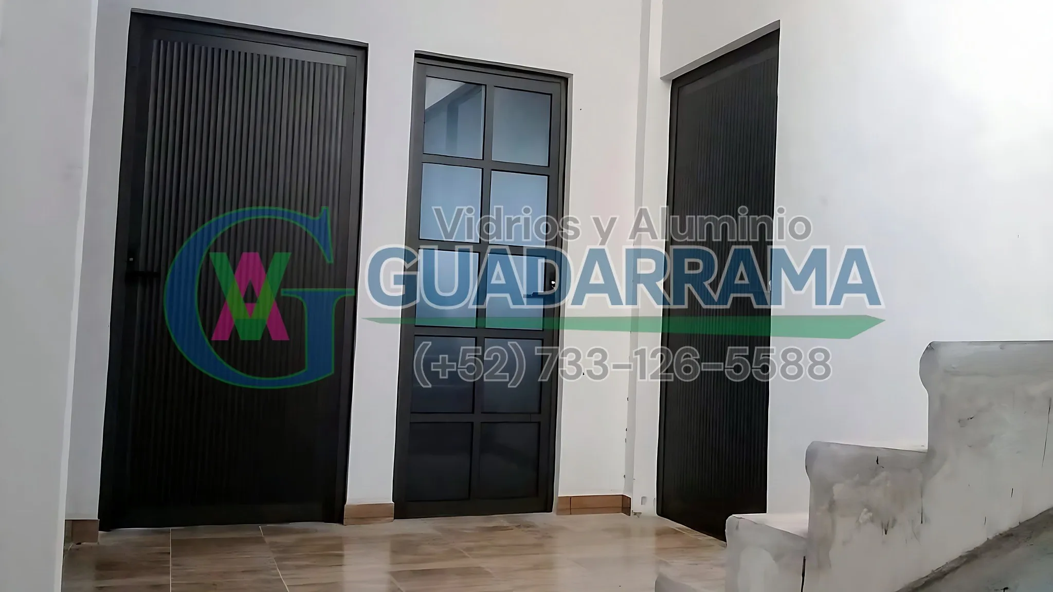 Una puerta abatible de aluminio negro con vidrio filtrasol.
