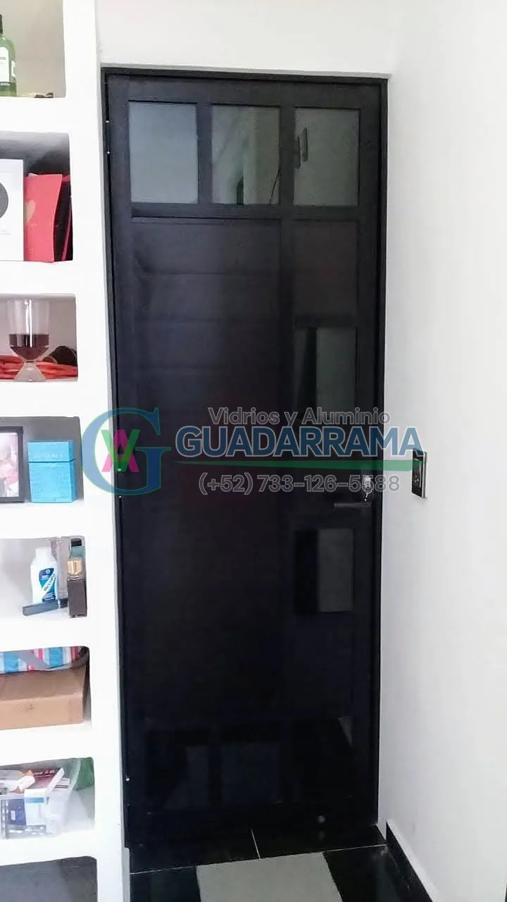 Puerta abatible en aluminio negro con vidrio filtrasol, un diseño elegante y funcional para cualquier espacio.