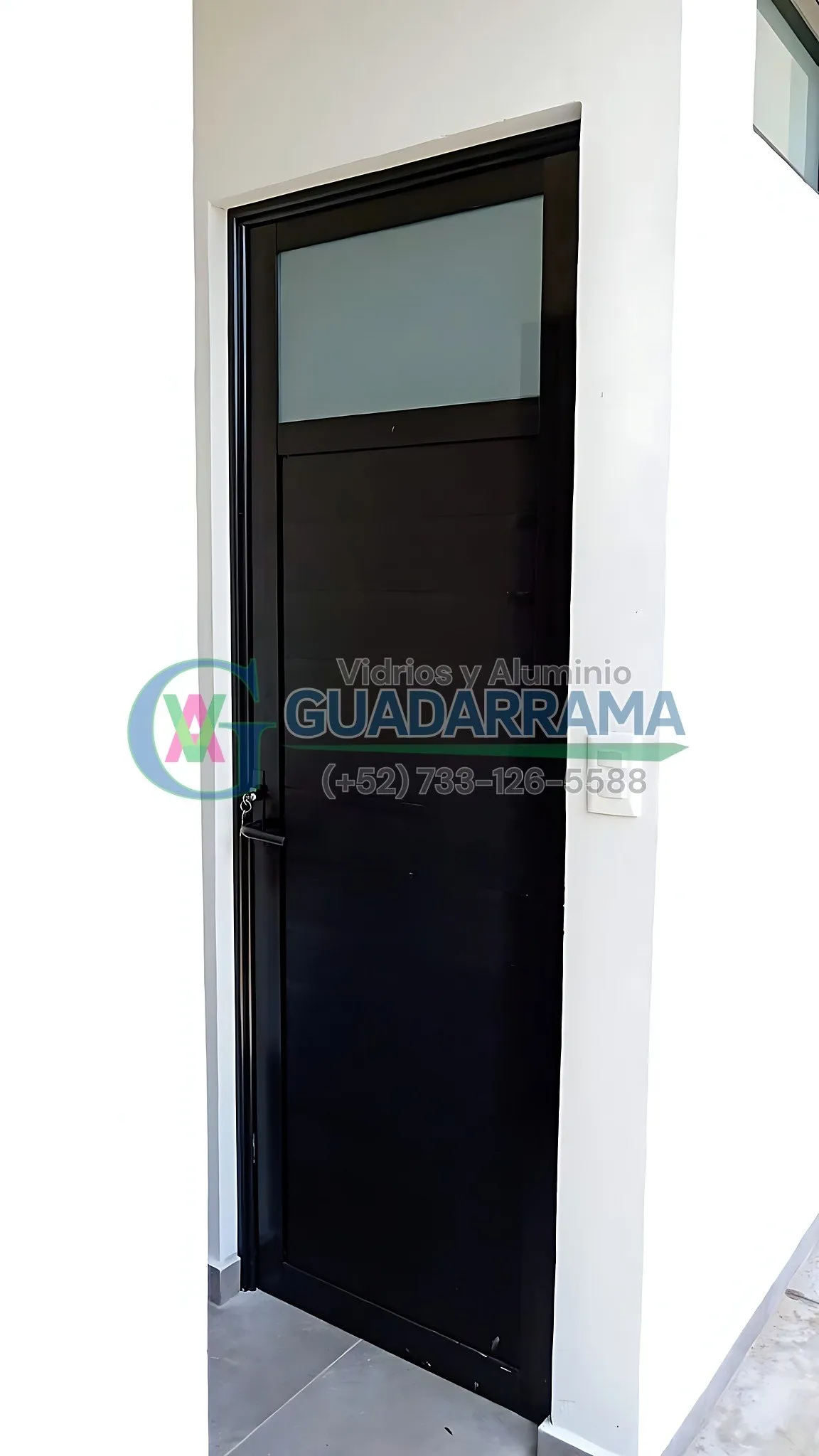 Puerta abatible en aluminio negro con duela lisa y vidrio templado esmerilado en la parte superior, ideal para entrada principal con privacidad sin perder luz natural.