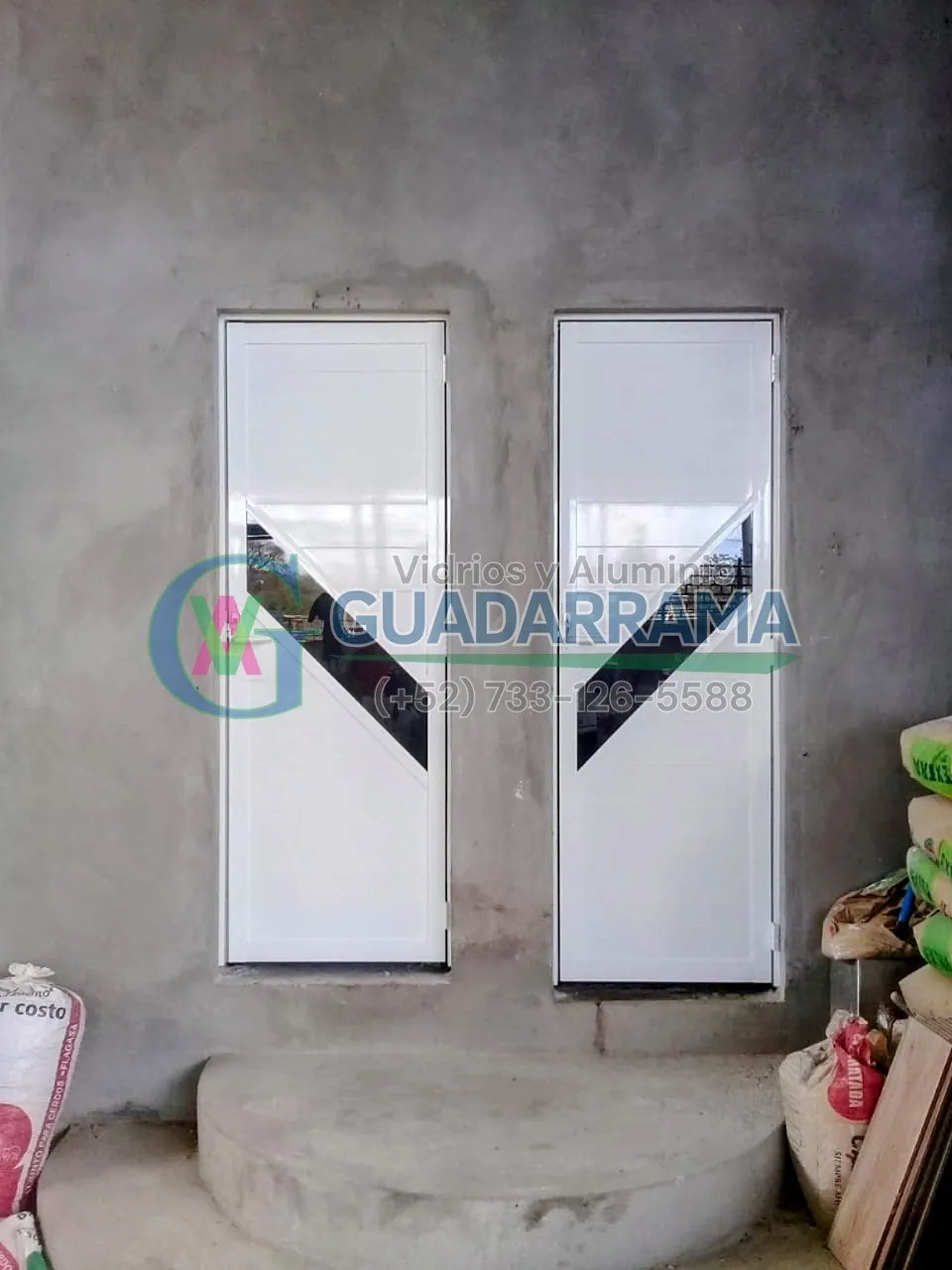 Puertas abatibles de aluminio blanco con detalle diagonal en vidrio, recién instaladas y listas para entregar.