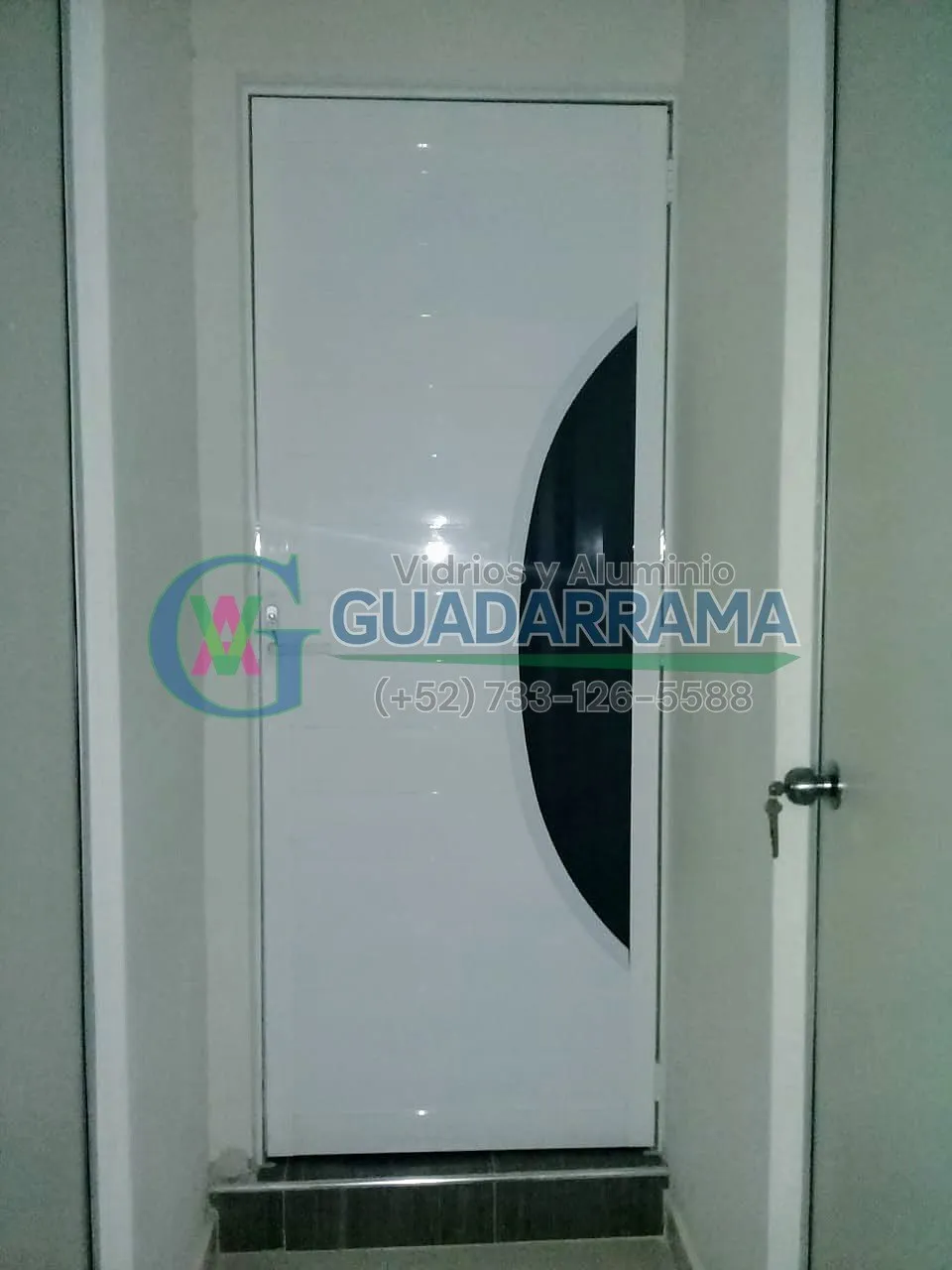Puerta de aluminio blanco con diseño curvo en negro y vidrio esmerilado, ideal para separar ambientes con estilo y privacidad.