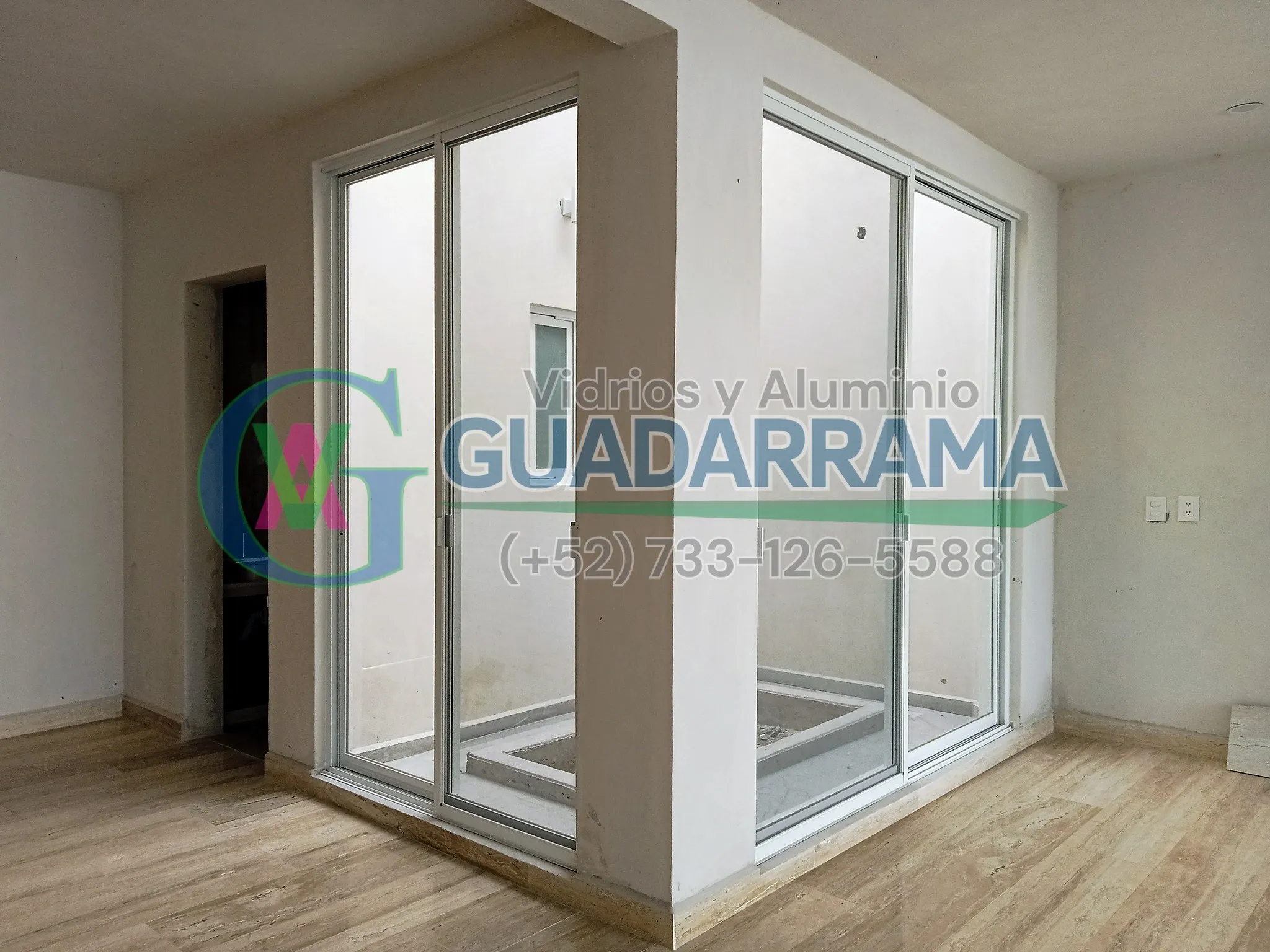 Una puerta corrediza de aluminio blanco con vidrio transparente.