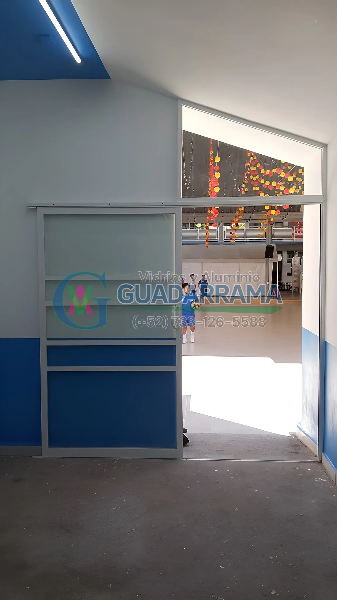 Puerta corrediza de aluminio blanco con vidrio transparente y película de seguridad para oficinas.