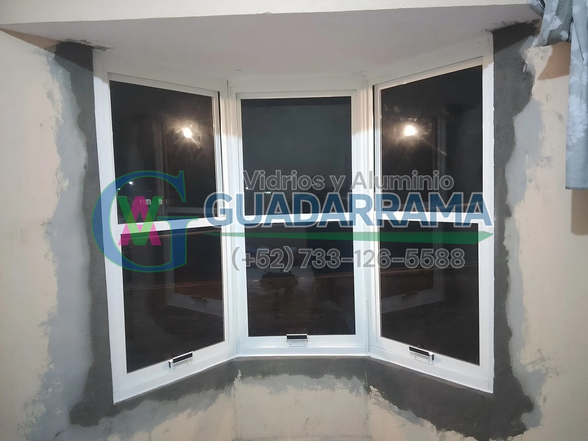 Una ventana corrediza en aluminio blanco con vidrio filtrasol.