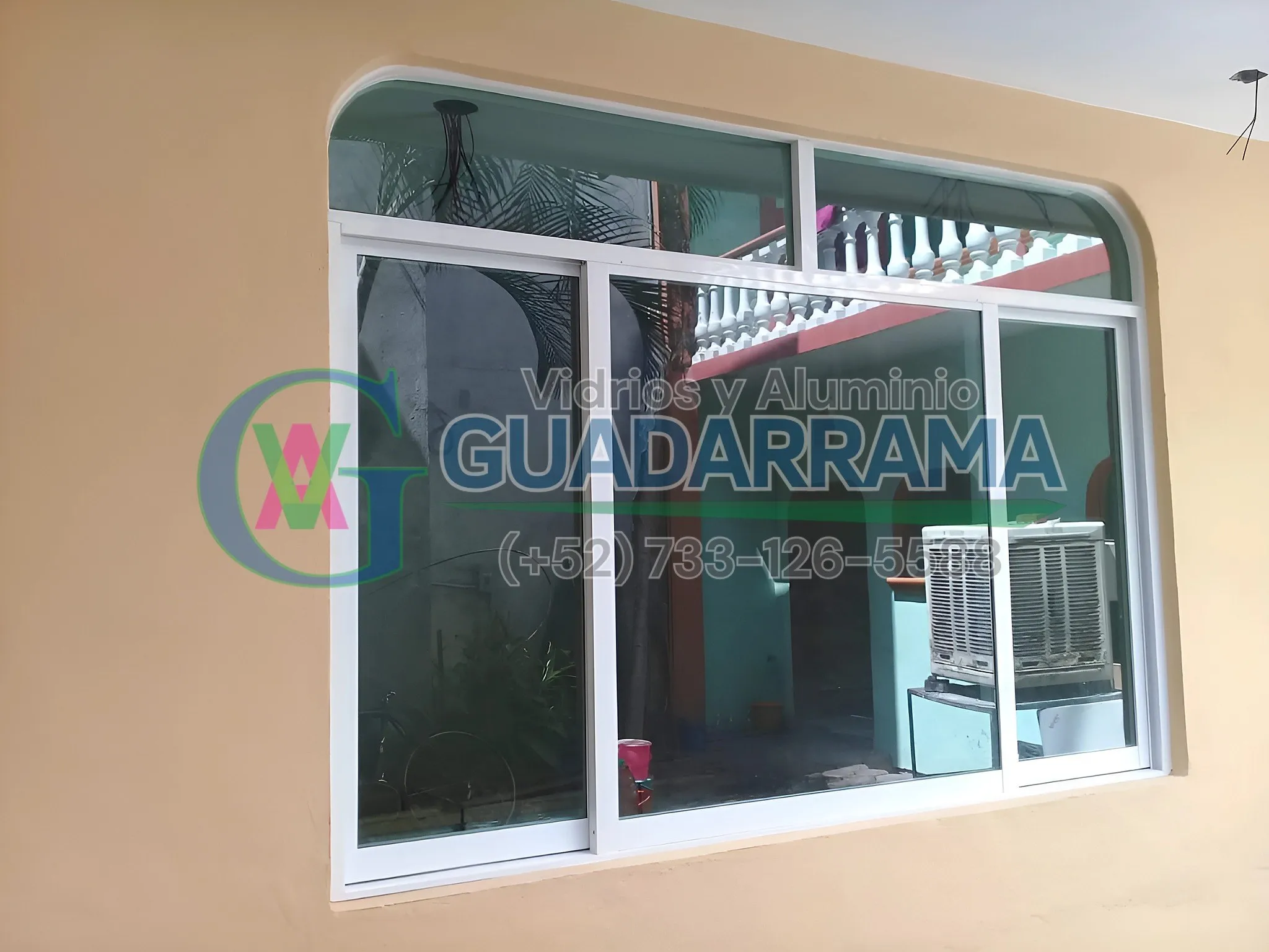Ventana corrediza de aluminio blanco para exterior, con panel de vidrio transparente y un toque de elegancia en su curvatura.