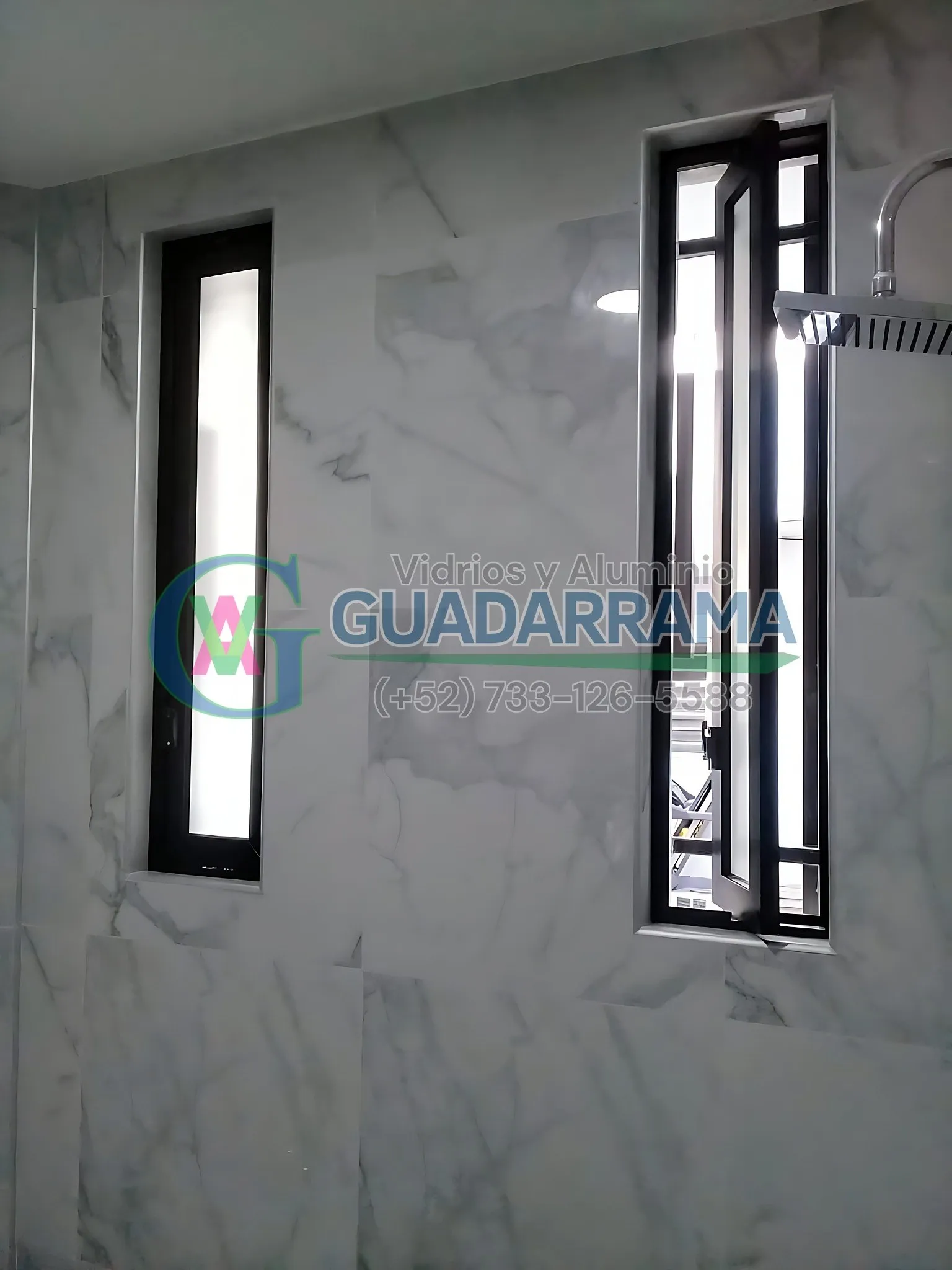 Cancel de baño con ventana pivotante de aluminio en negro y vidrio esmerilado, ideal para ganar privacidad sin renunciar a la luz natural.
