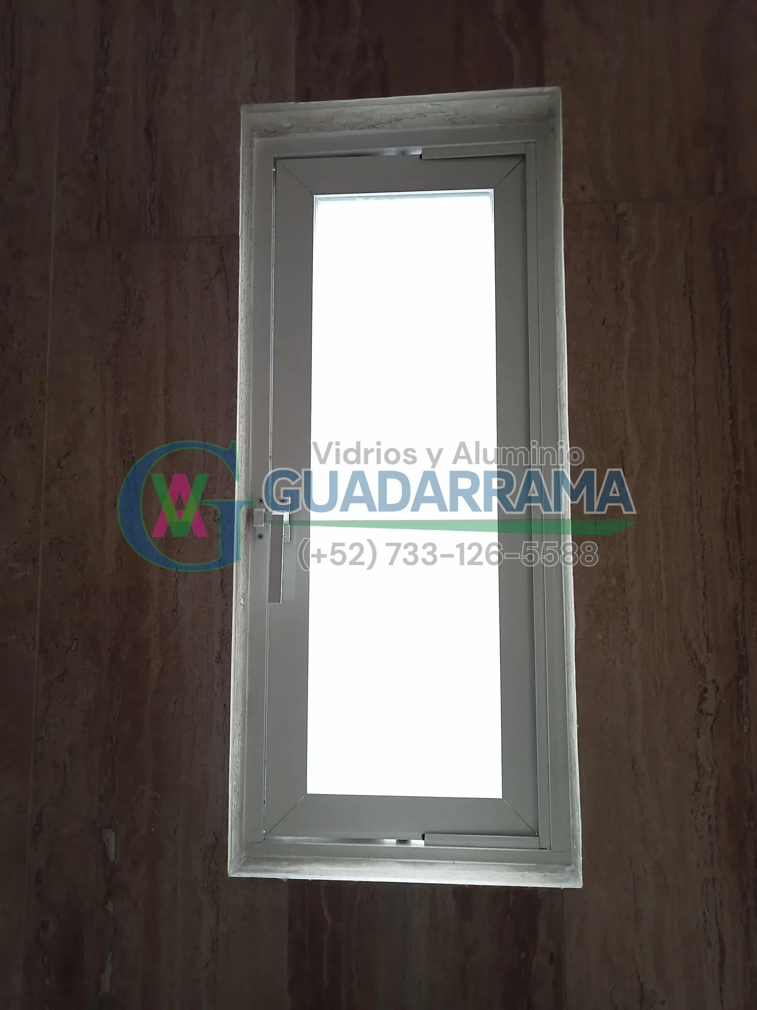 Ventana oscilobatiente para baño, con perfil de aluminio blanco y vidrio transparente esmerilado.