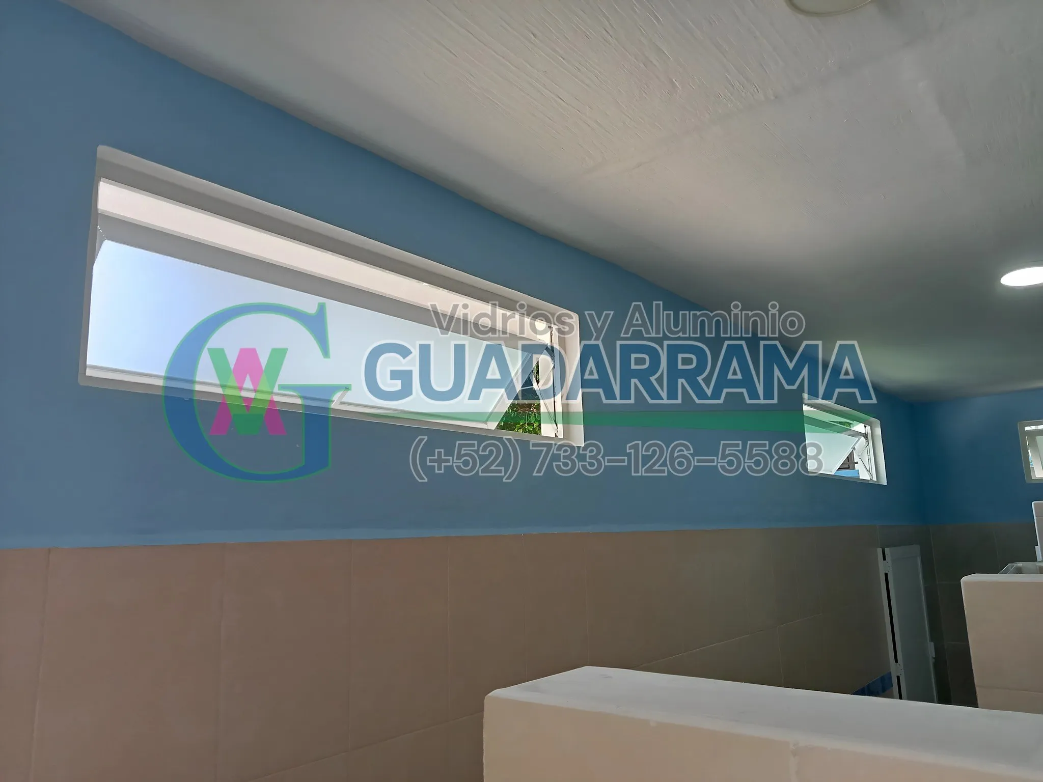 Ventana proyectante de baño con marco blanco y vidrio transparente esmerilado.